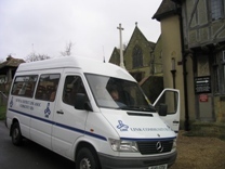 A minibus waiting for passengers outside a church